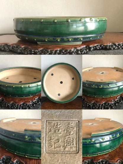 A green glazed ceramic bonsai pot with raised dots and a square stamped mark.