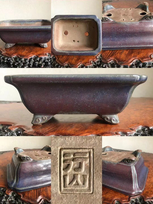Dark purple glazed rectangular pot with four feet and a square maker’s mark.
