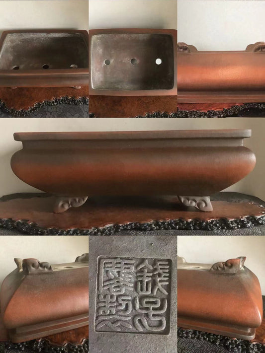 A dark brown, glossy, rectangular bonsai pot with three holes and carved feet, featuring a square seal with characters.
