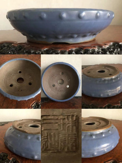 Blue glazed ceramic pot with raised bumps around rim and stamped characters on base.