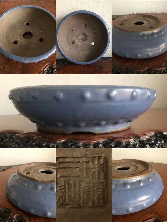 Blue glazed ceramic pot with raised bumps around rim and stamped characters on base.
