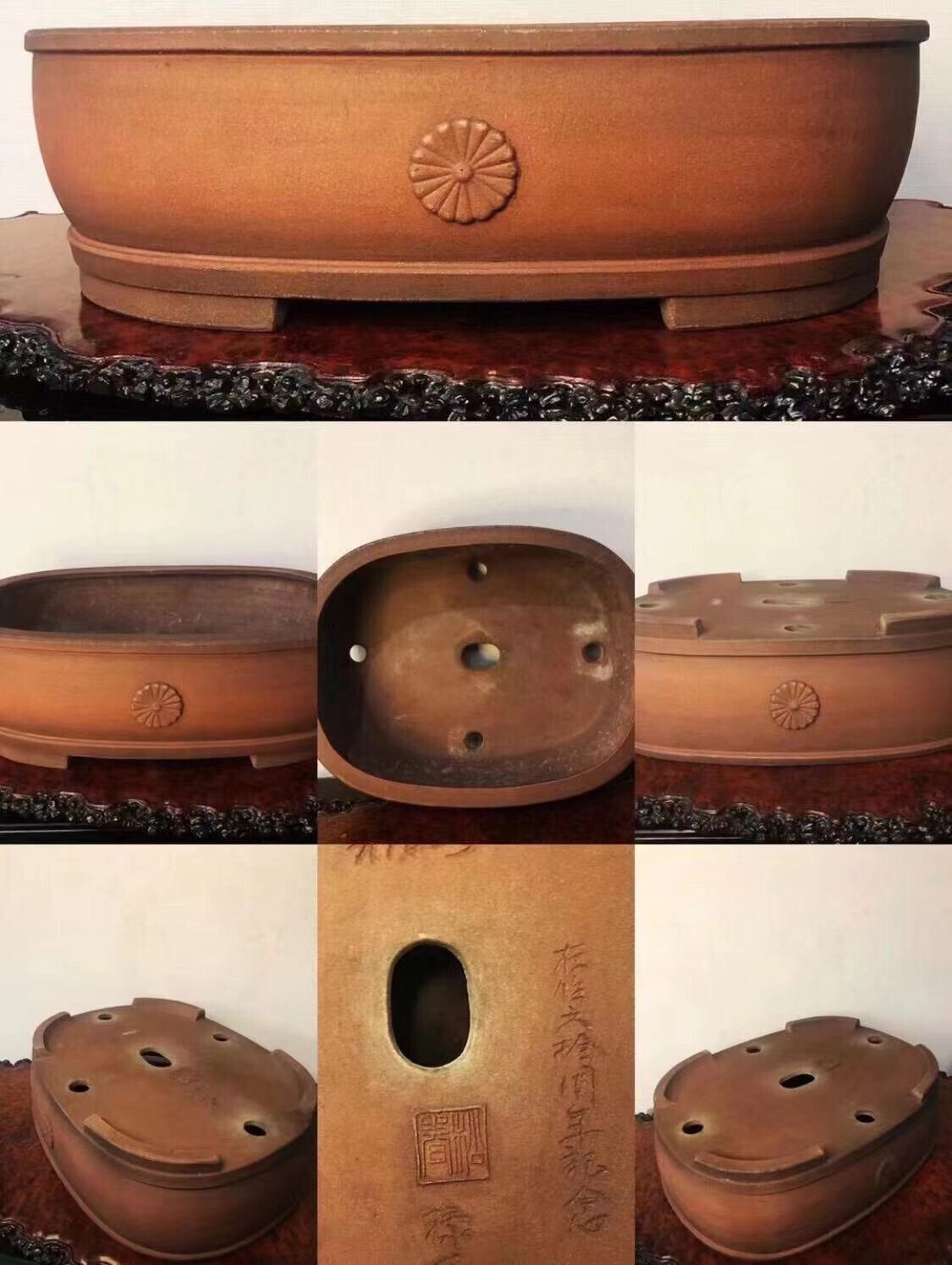 A brown glazed bonsai pot with a sunburst decoration and carved characters on its side.
