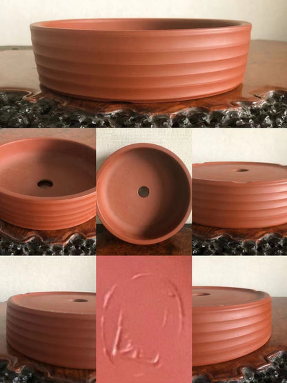 A terracotta bonsai pot with horizontal ridges and a central drainage hole.