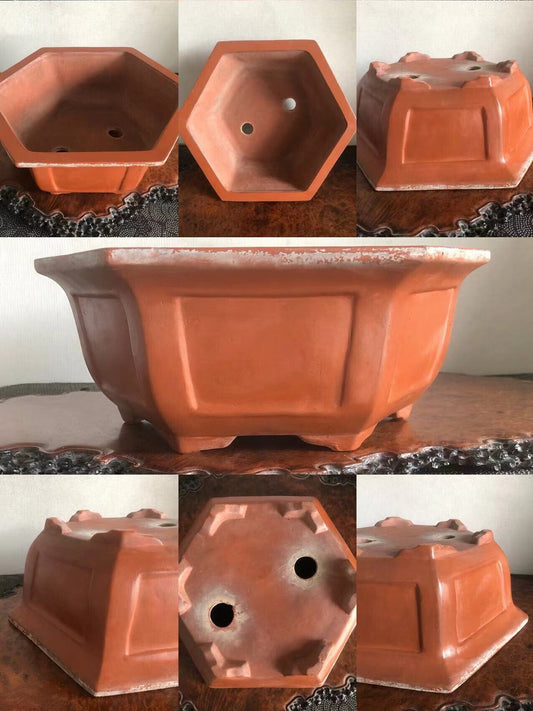 Hexagonal terracotta pot with matte finish, showing drainage holes and raised edges.