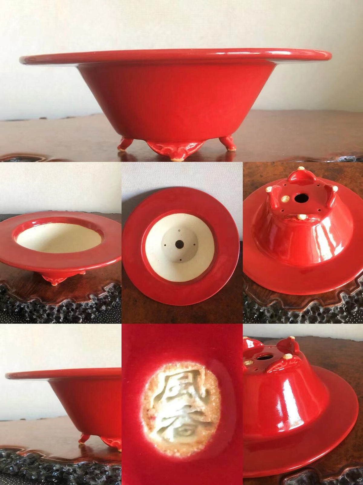 A glossy red ceramic pot with three feet and a gold-embossed character on its base.