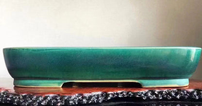 A glossy teal glazed rectangular pot with a low rim and footed base.