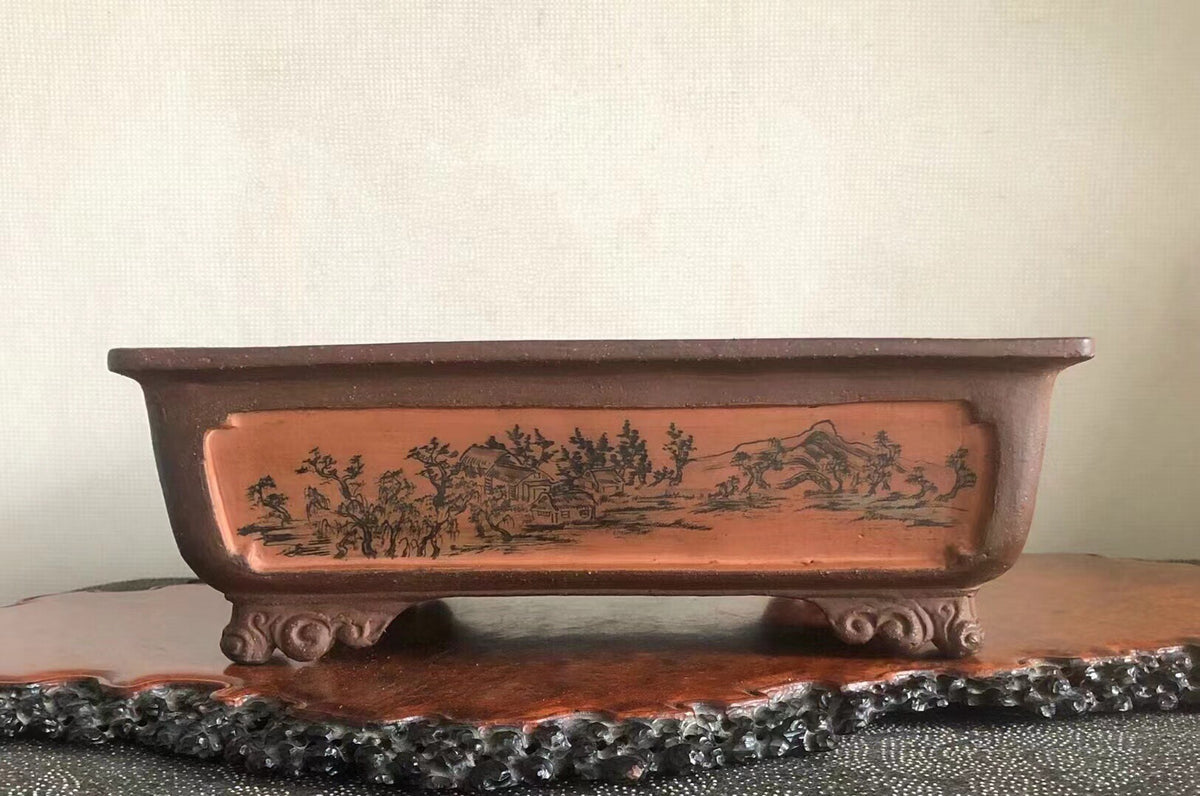 Rectangular terracotta pot with glazed brown surface, featuring a black ink landscape scene on its side.