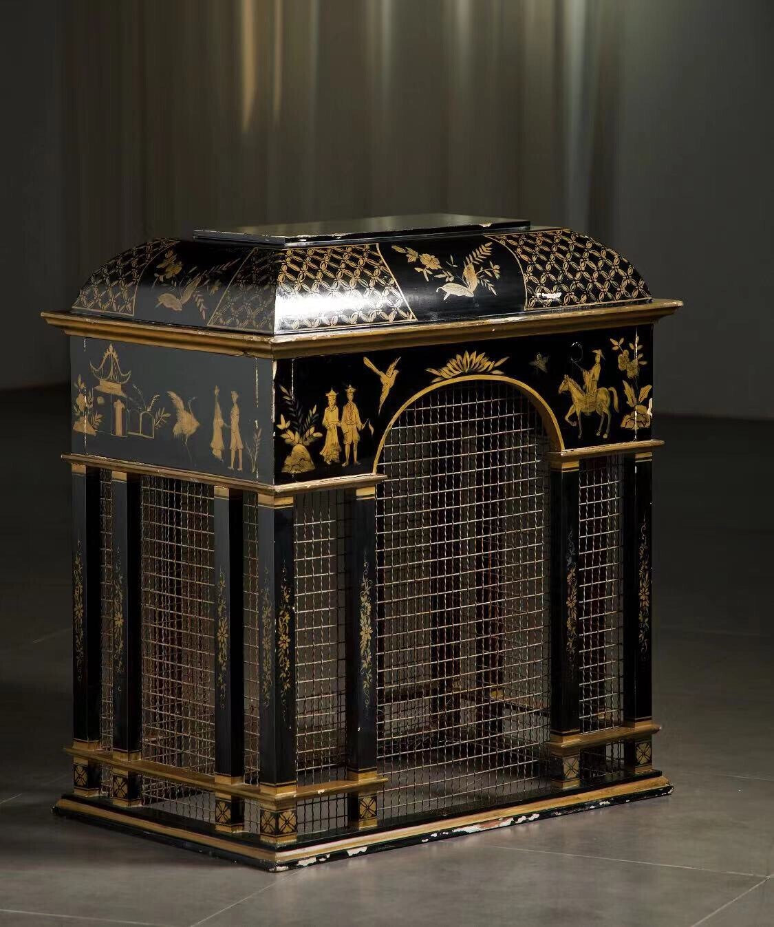 Black lacquered cabinet with gold painted scenes and wire mesh panels.
