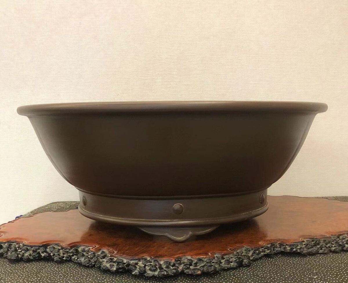 Dark brown glazed ceramic bonsai pot with a wide rim and a single central foot.