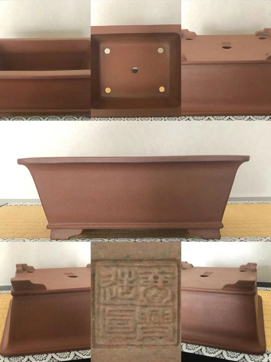 A matte brown rectangular pot with four footed legs and a central stamped seal.