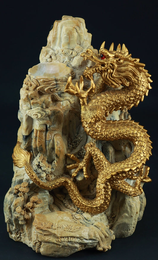 A golden dragon sculpture coils around a textured, light-colored rock formation with red eyes.