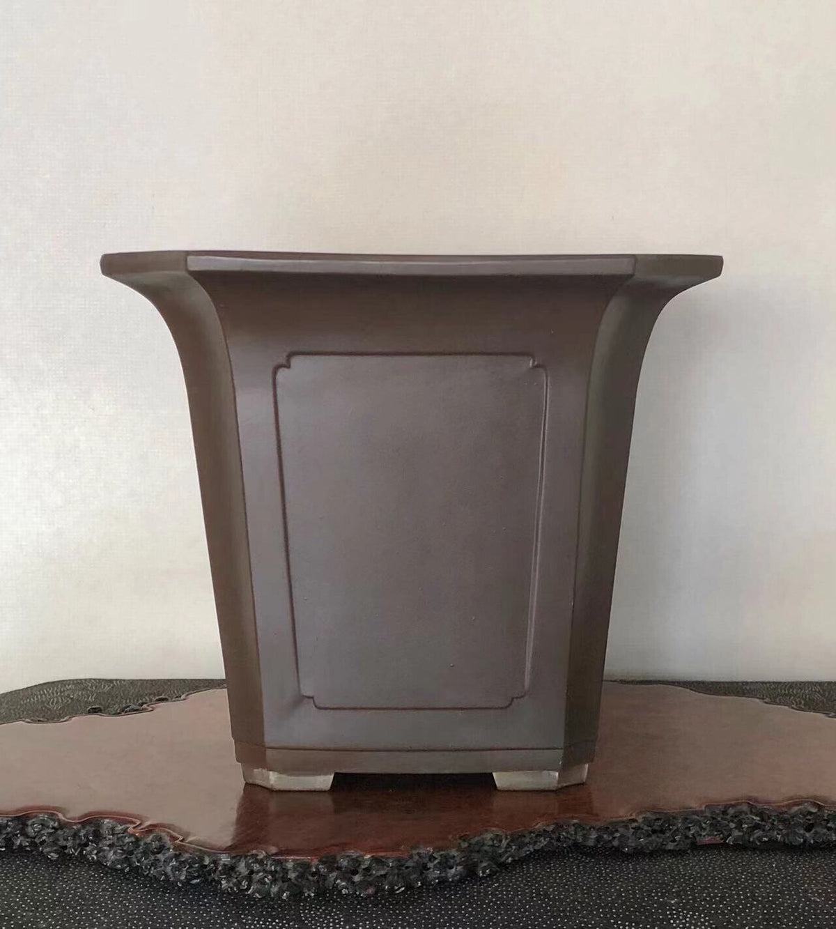 Dark brown glazed ceramic pot with flared rim and recessed rectangular panel.