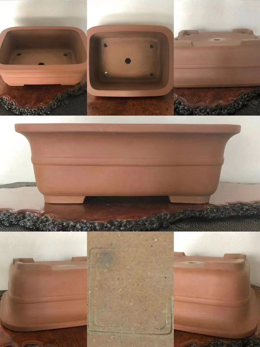 A terracotta bonsai pot, rectangular with rounded corners, unglazed matte finish, four drainage holes.