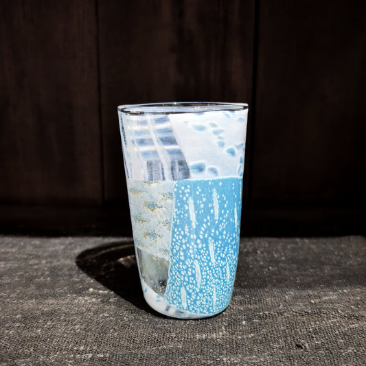 Tall glass tumbler built from pale blue and white mosaic panels with a frosted, icy surface.