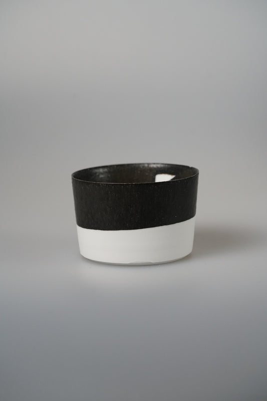 Low cup banded in matte black above bright white, with clean straight sides.