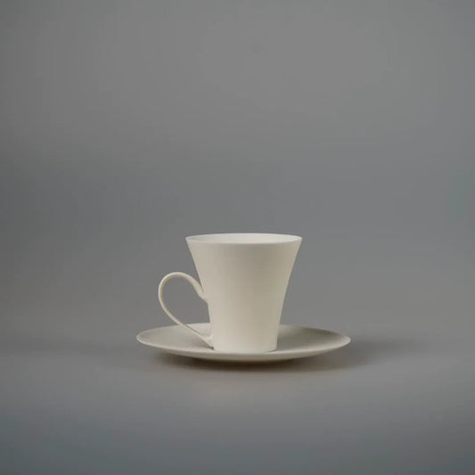 Slender white porcelain cup with a tiny ring handle, standing on a matching white saucer.